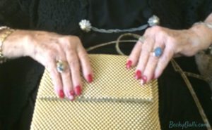 Her bejeweled fingers opened her stylish gold purse